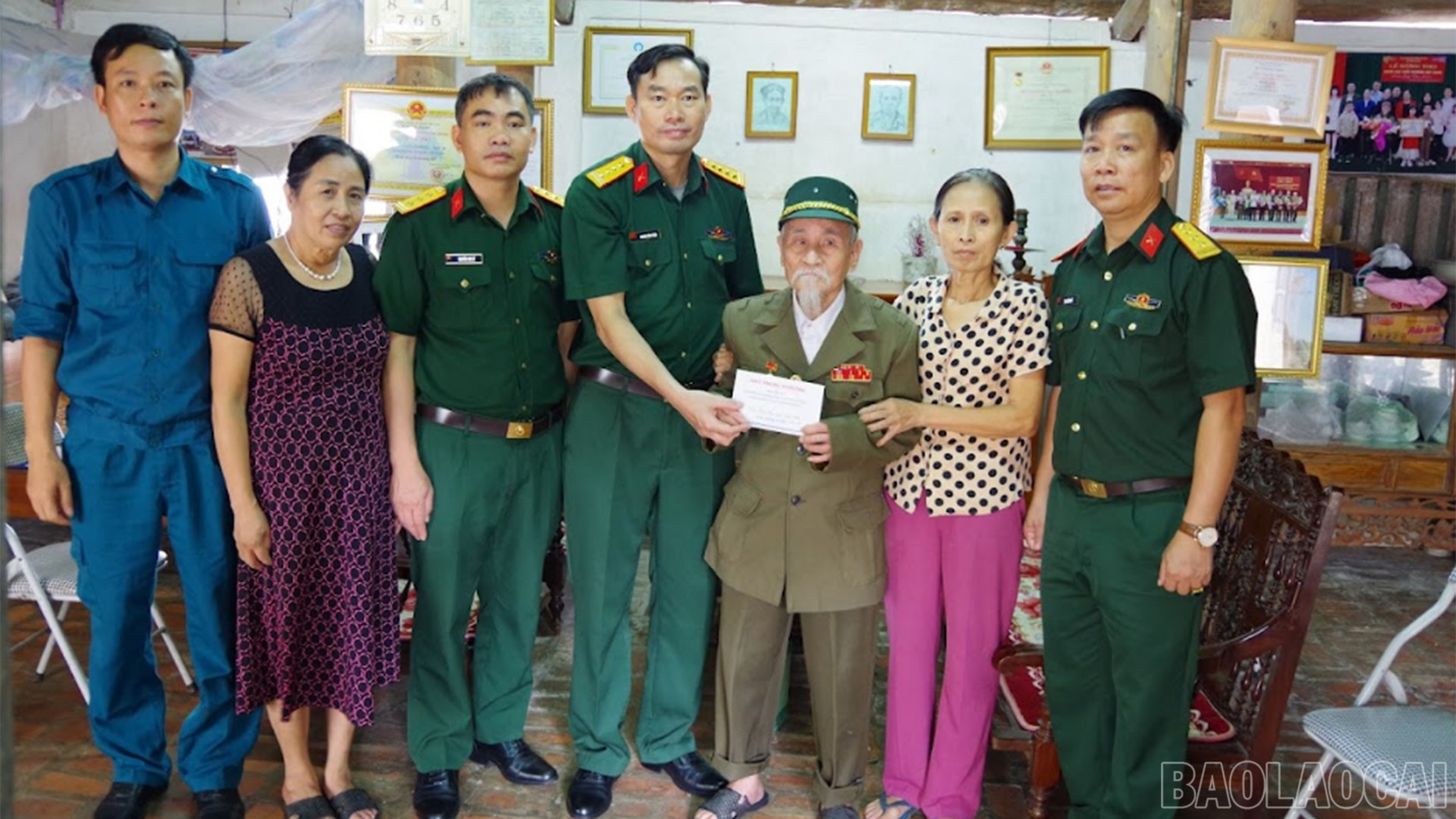 Thừa ủy quyền của Quân ủy Trung ương - Bộ Quốc phòng, Đại tá Hoàng Văn Toàn - Phó Chính ủy Bộ CHQS tỉnh trao quà cho các đồng chí có công với cách mạng trên địa bàn tỉnh baolaocai-br_29-8-bochqs3.jpg