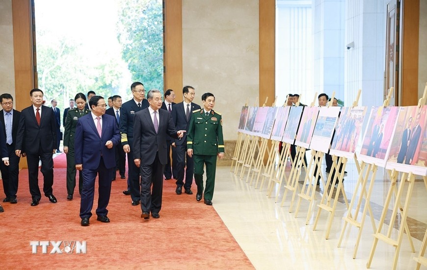 Thủ tướng Phạm Minh Chính cùng các Bộ trưởng Ngoại giao, Quốc phòng, Công an Việt Nam và Trung Quốc tham quan trưng bày ảnh về quan hệ hợp tác giữa hai nước.