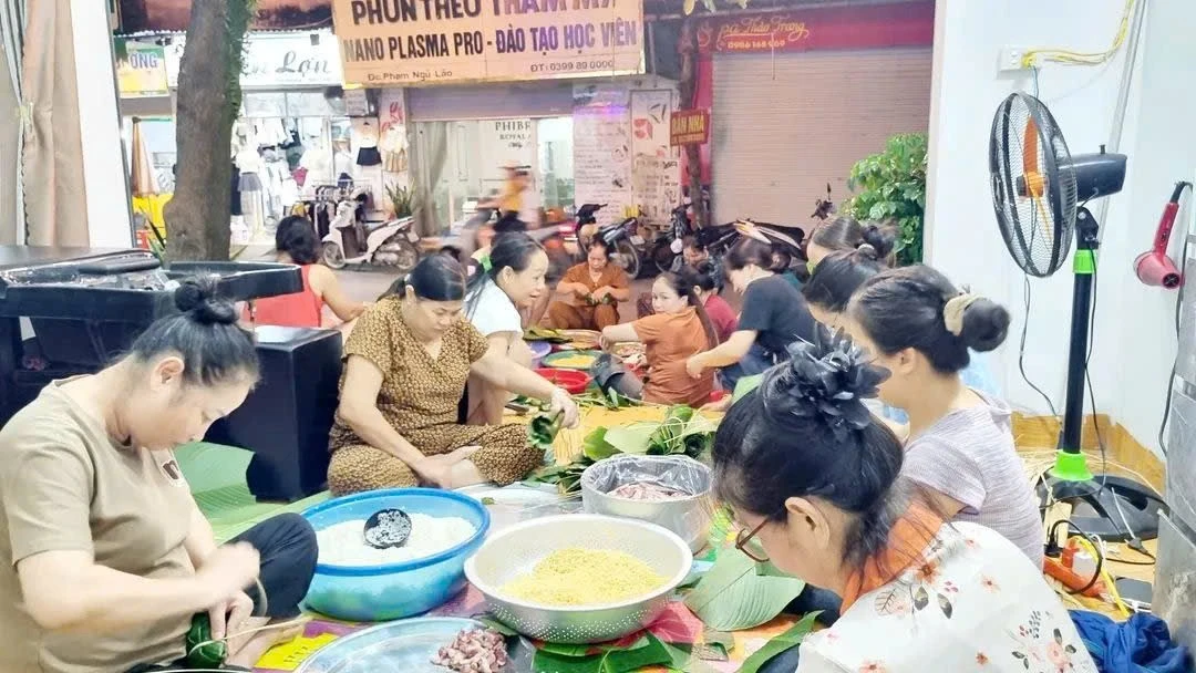 Lực lượng CSGT cùng hàng chục người dân cùng nhau gói bánh chưng từng bàn tay thoăn thoắt, từng nắm nếp, miếng thịt, lá dong được xếp ngay ngắn để chuyển đi Thái Nguyên.