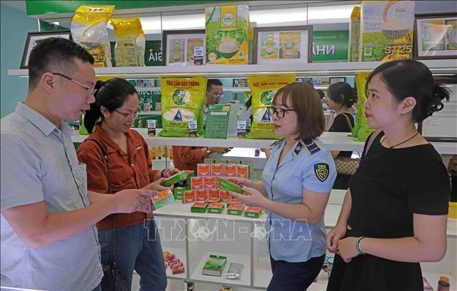 Lực lượng QLTT hướng dẫn người dân nhận biết hàng thật, hàng giả. Ảnh tư liệu