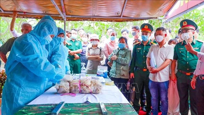 Đại biểu và các lực lượng chức năng theo dõi quy trình lấy mẫu hài cốt liệt sĩ chưa xác định thông tin tại Nghĩa trang Liệt sĩ Đức Huệ. Ảnh: Minh Phú/TTXVN