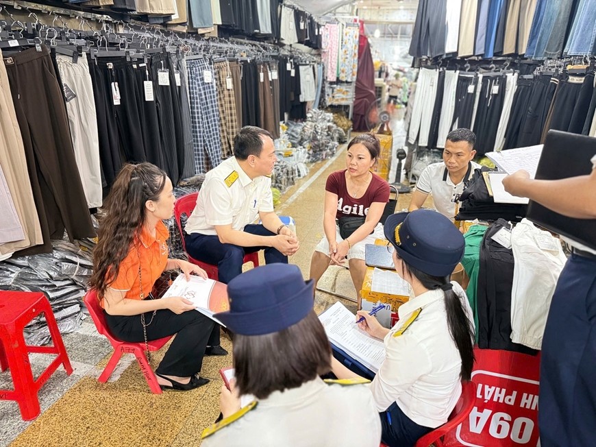 Cán bộ ngành thuế hướng dẫn hộ kinh doanh chuyển đổi mô hình từ thuế khoán sang kê khai. Ảnh: HUY HÙNG