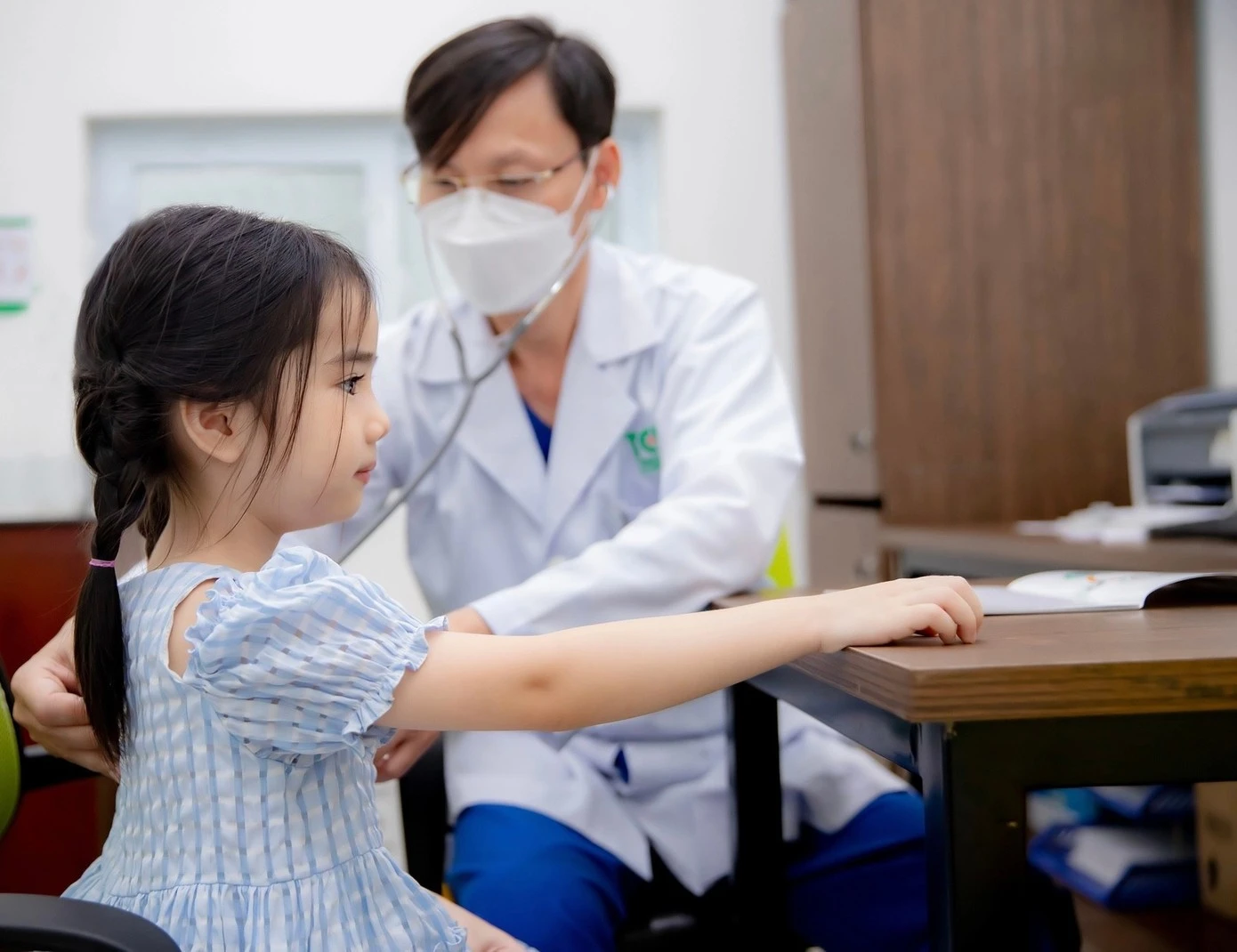 Bác sĩ thăm khám cho trẻ trước khi tiêm vắc xin phòng bệnh tả.