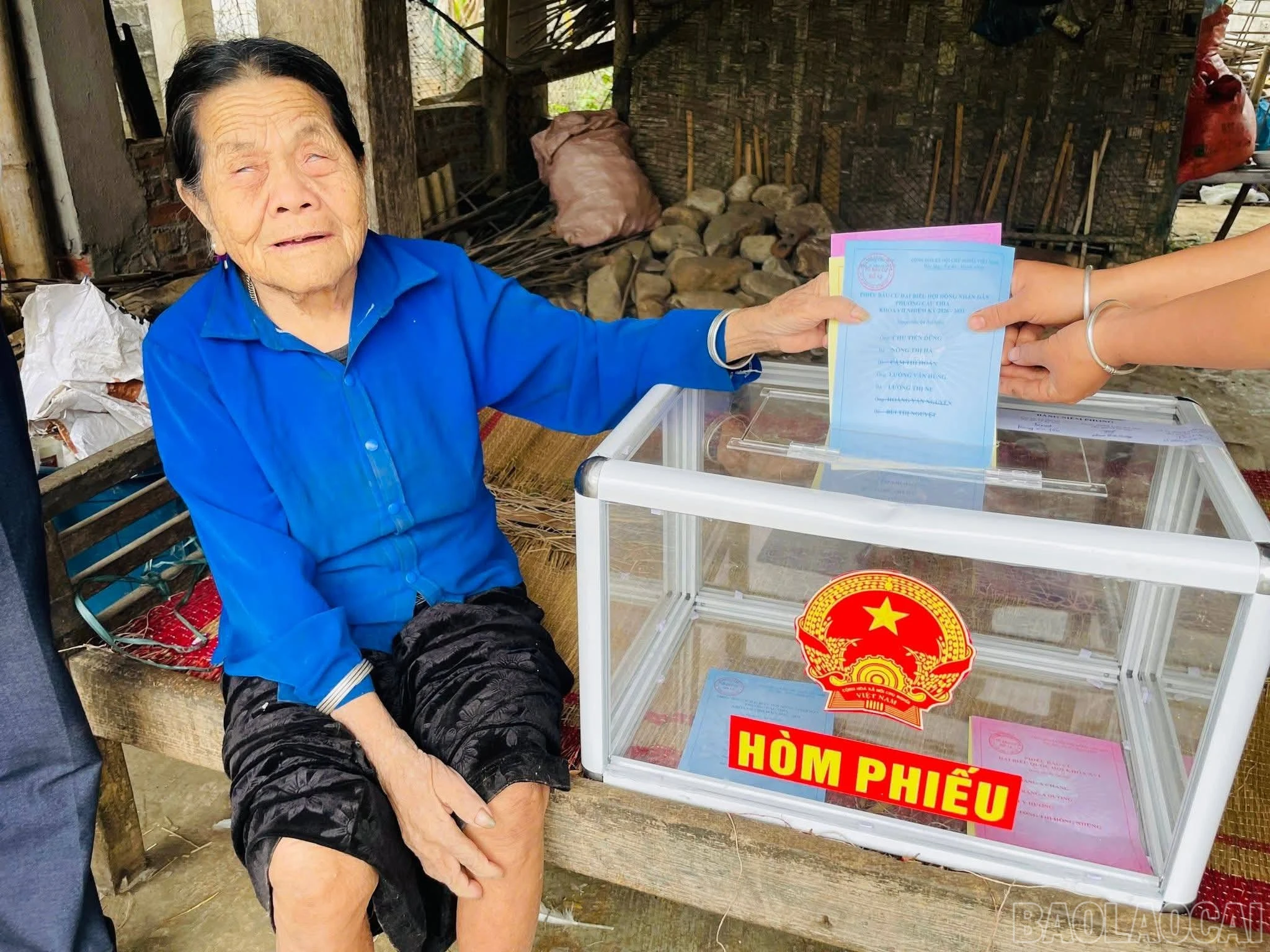 Cử tri cao tuổi tại phường Nghĩa Lộ bỏ phiếu tại hòm phiếu phụ được mang đến tận nhà.