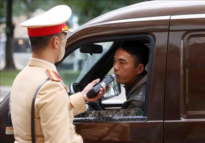 Cán bộ, chiến sĩ đội CSGT số 4 lập chốt kiểm tra nồng độ cồn với các chủ phương tiện tham gia giao thông tại tuyến phố Nguyễn Đình Chiểu.