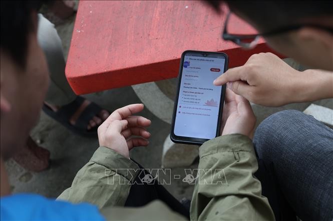 Sinh viên Trường Đại học Bách khoa, Đại học Đà Nẵng hướng dẫn nhau cách thay đổi nơi bỏ phiếu trên app VNeID.