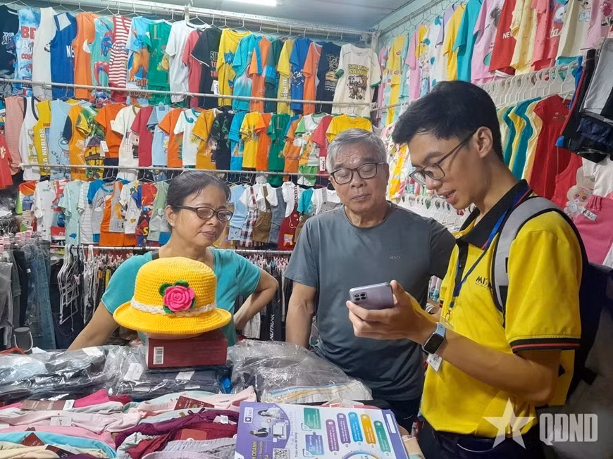 Nhân viên Công ty Cổ phần MISA tư vấn hộ kinh doanh về phần mềm kê khai nộp thuế cài đặt trên điện thoại thông minh. Ảnh: HÀ TRANG