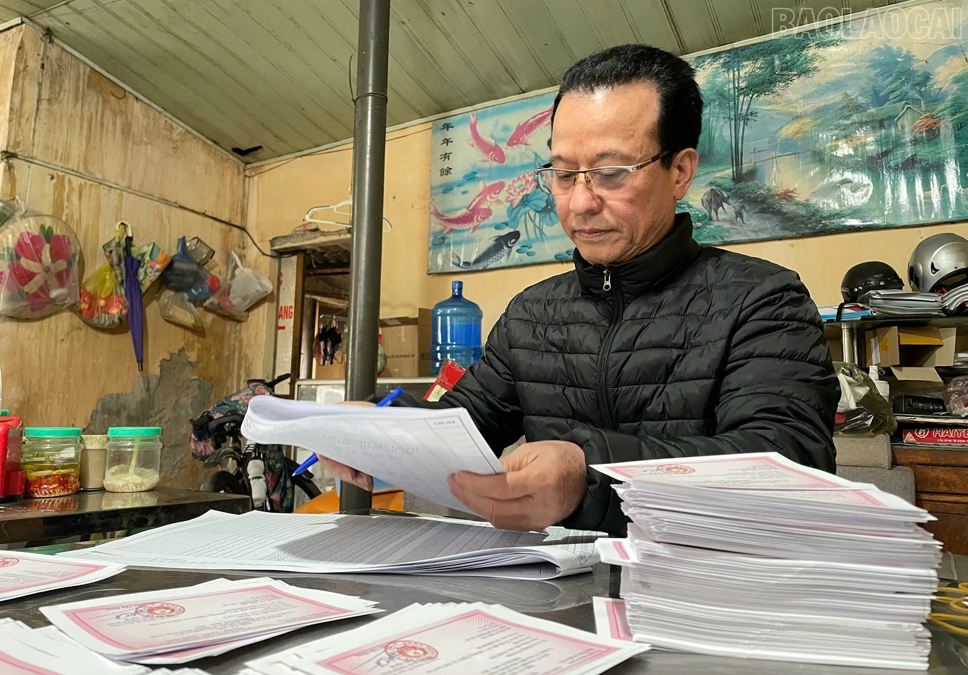 Ông Đào Ngọc Thanh - Tổ trưởng tổ dân phố 2, phường Nghĩa Lộ rà soát lại thẻ cử tri trước khi phát đến tay cử tri.