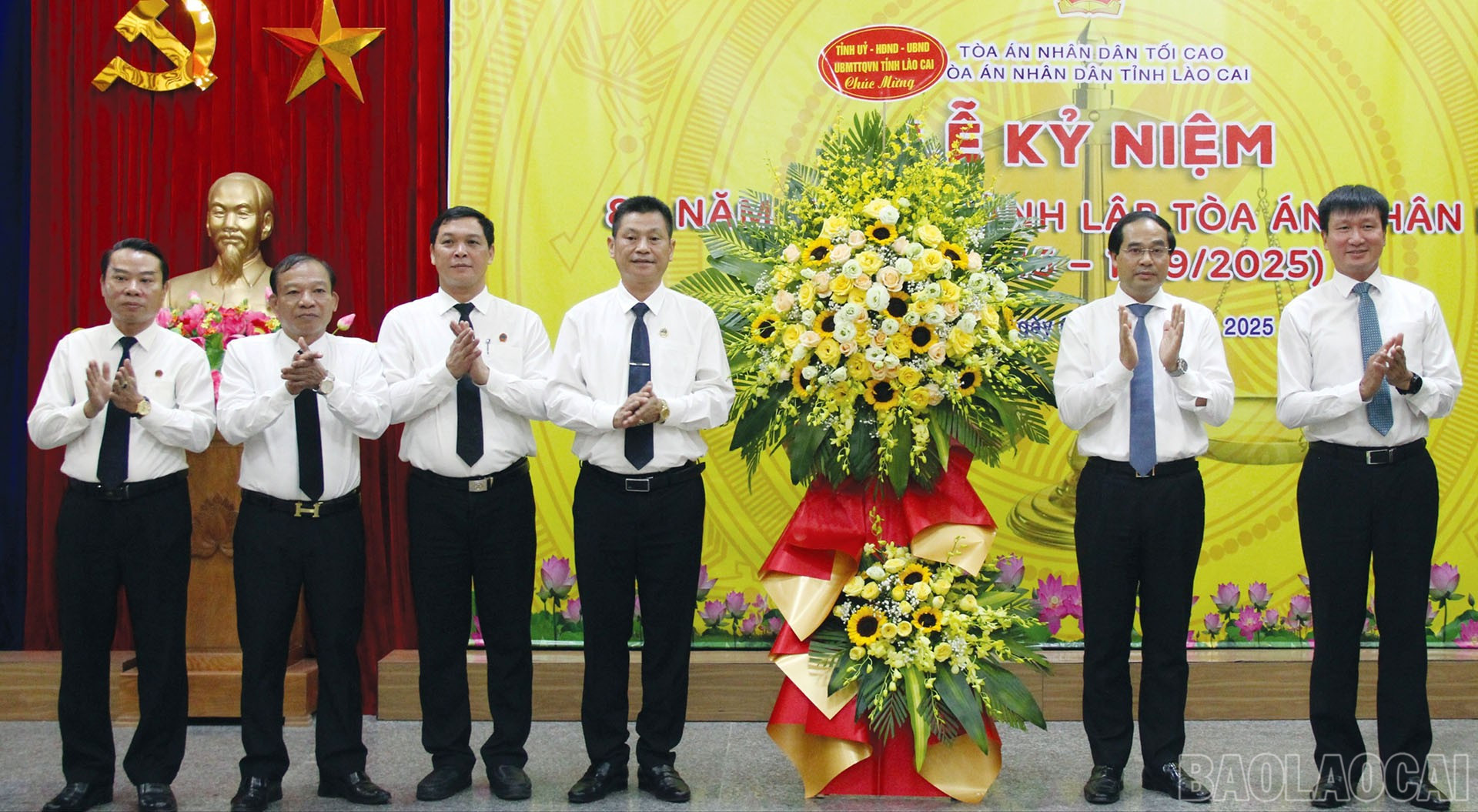 Các đồng chí Trịnh Xuân Trường - Bí thư Tỉnh ủy; Trần Huy Tuấn - Chủ tịch UBND tỉnh tặng hoa chúc mừng và bức cờ thêu dòng chữ “Phụng công - Thủ pháp - Chí công - Vô tư” cho Toà án nhân dân tỉnh. baolaocai-br_9-9-tanghoa.jpg