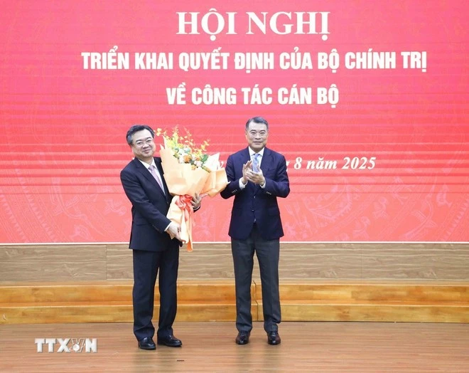 Đồng chí Lê Minh Hưng, Uỷ viên Bộ Chính trị, Bí thư Trung ương Đảng, Trưởng Ban Tổ chức Trung ương tặng hoa chúc mừng đồng chí Nguyễn Thanh Nghị. (Ảnh: Phương Hoa/TTXVN)