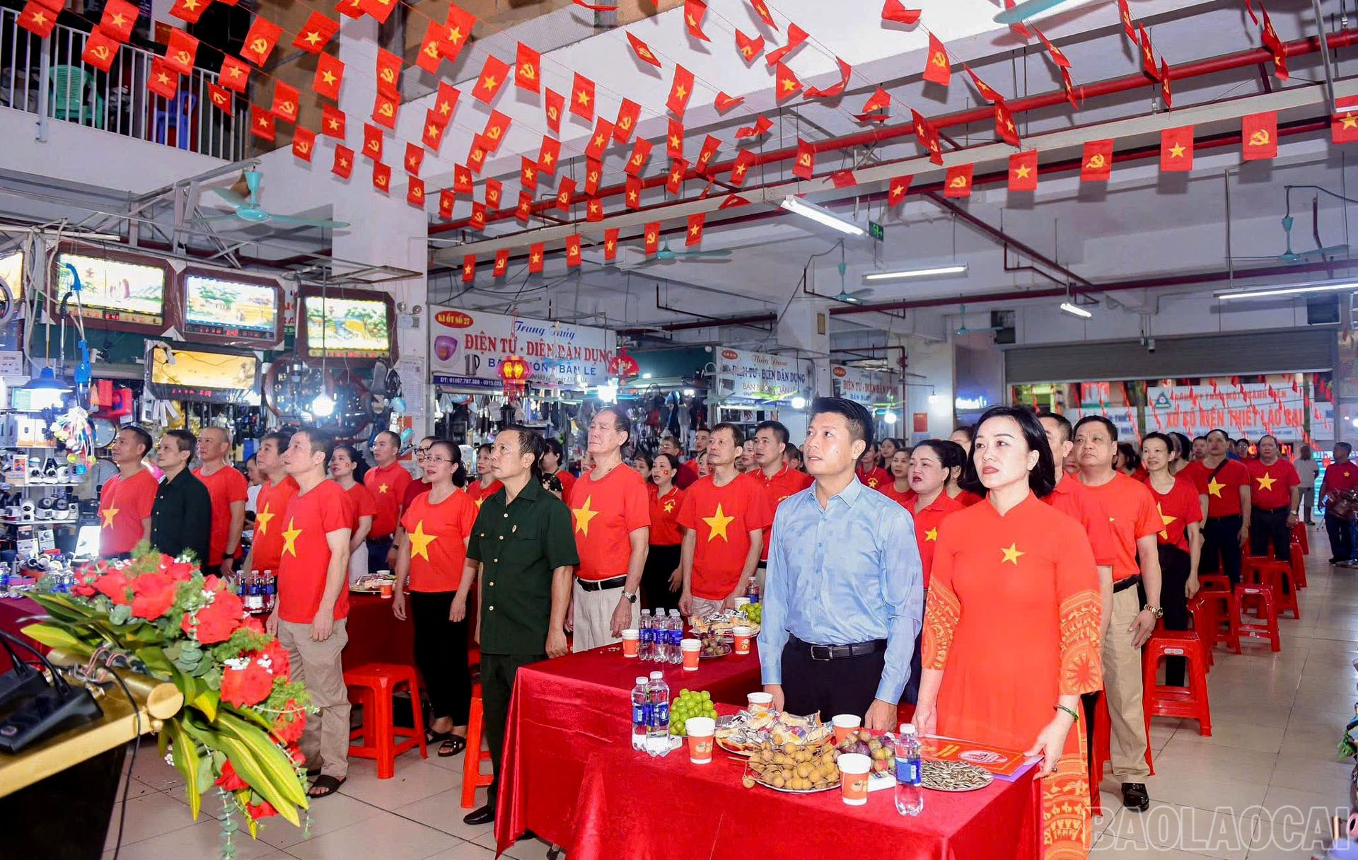 Các tiểu thương chợ Cốc Lếu, phường Lào Cai theo dõi Lễ kỷ niệm. baolaocai-br_2-9-b-sung4.jpg
