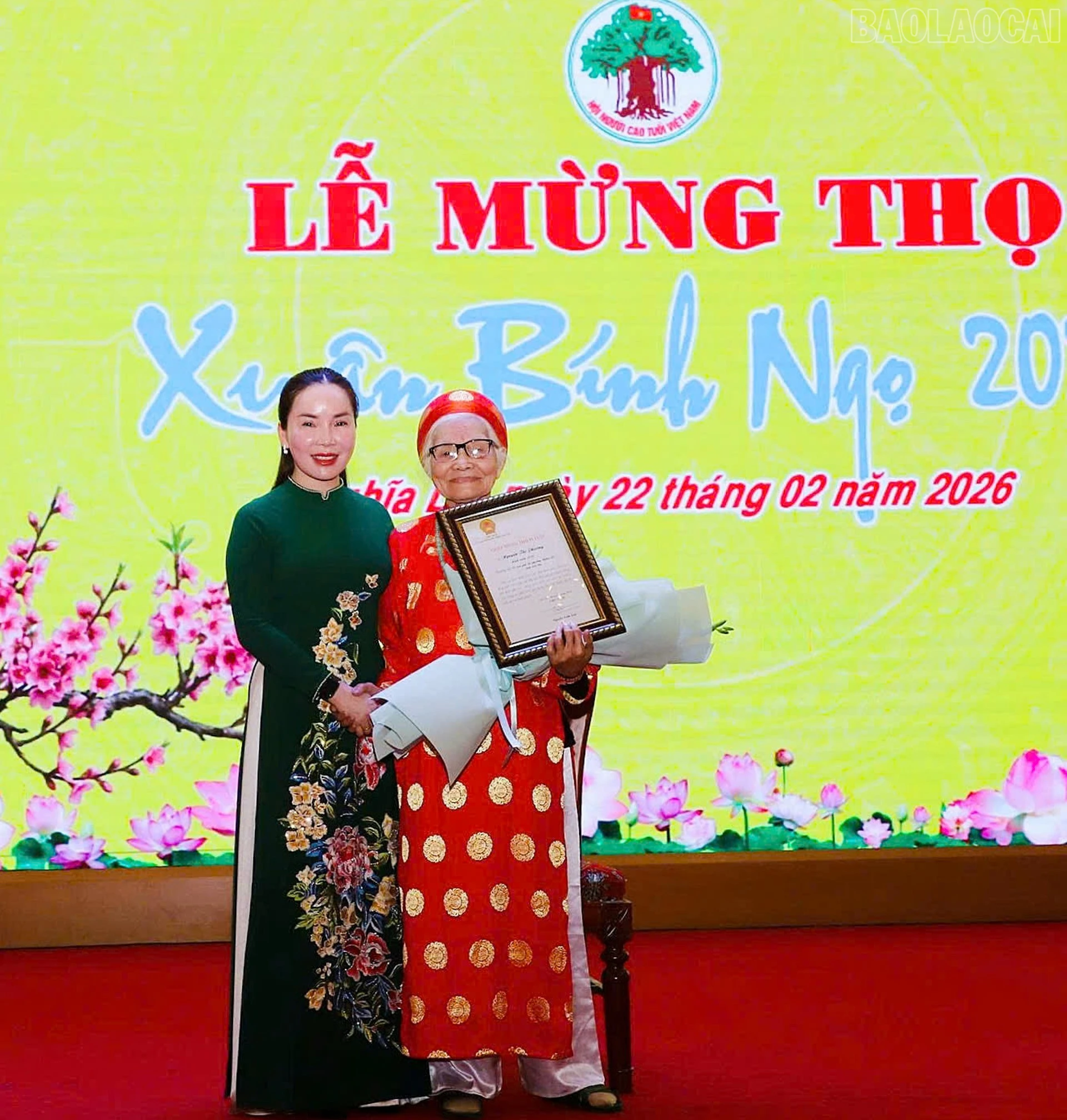 Đồng chí Phó Bí thư Thường trực Đảng ủy phường Nghĩa Lộ tặng hoa và trao chứng nhận chúc thọ và tặng hoa cho cụ 95 tuổi.