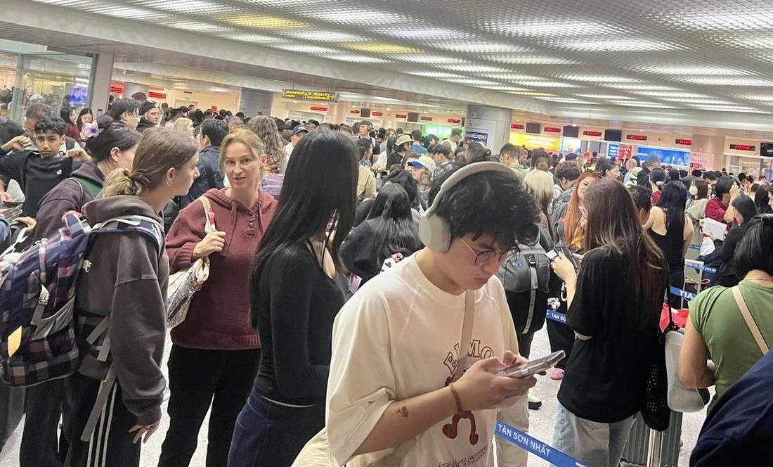 Hành khách rồng rắn xếp hàng chờ qua khu vực nhập cảnh ở sân bay Tân Sơn Nhất (TP.HCM) vào sáng 7-7