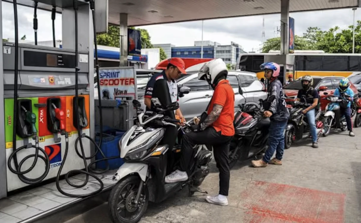 Người dân xếp hàng đổ xăng tại một trạm xăng ở Manila.