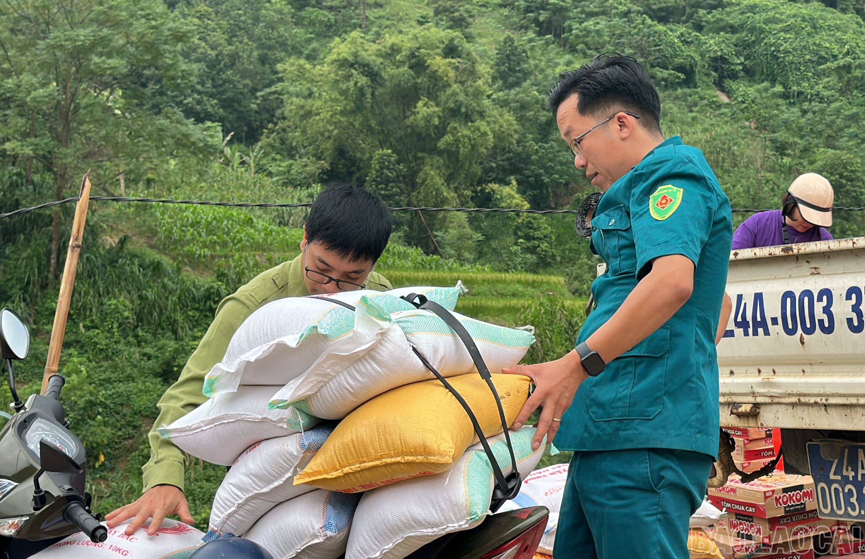 Anh Nguyễn Quang Hướng - Chỉ huy trưởng Ban Chỉ huy Quân sự xã Gia Phú đón hàng cứu trợ bằng xe máy. baolaocai-br_a3.jpg