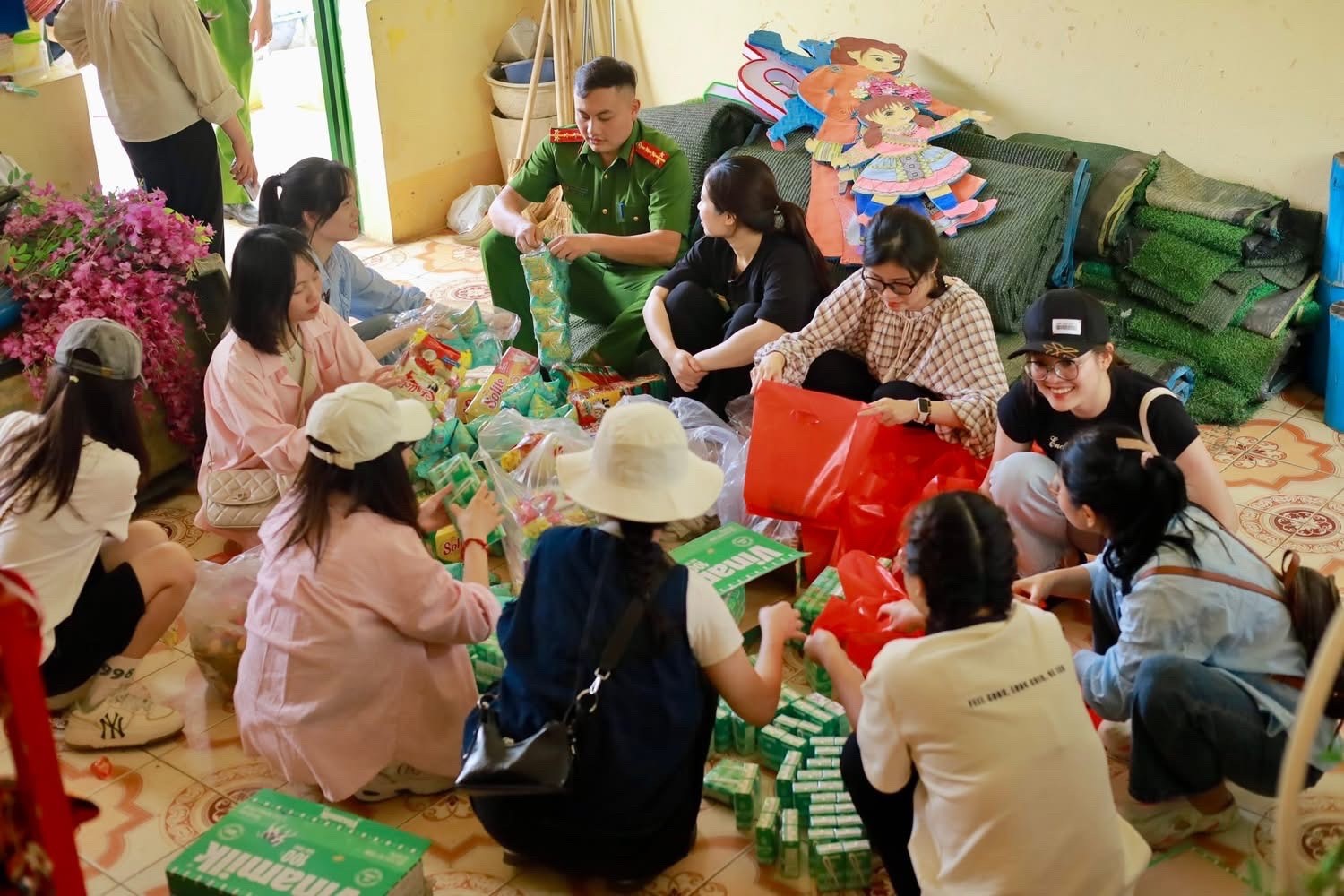 Các thành viên chia quà cho học sinh. z6750614734936-b7109dfeb543e14e573a37212c3b277b.jpg