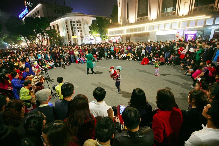 Một tiết mục biểu diễn nghệ thuật thu hút người xem vào buổi tối cuối tuần tại phố đi bộ hồ Gươm (Hà Nội).