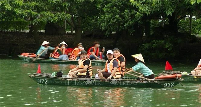 Du khách tham quan quần thể danh thắng Tràng An (Ninh Bình).