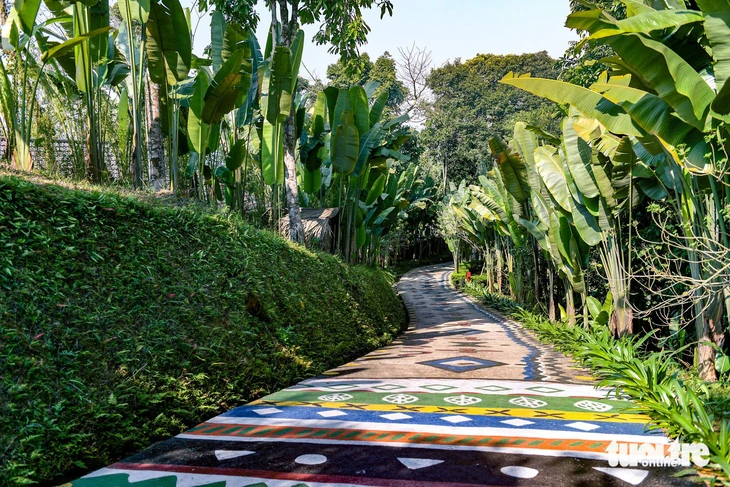 Con đường thổ cẩm do người dân bản địa vẽ nằm giữa không gian xanh mát.