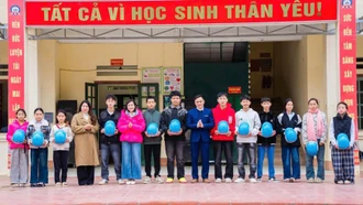 Tặng mũ bảo hiểm in logo - sản phẩm truyền thông của Dự án 8 cho học sinh