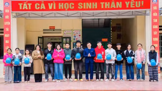 Tặng mũ bảo hiểm in logo - sản phẩm truyền thông của Dự án 8 cho học sinh