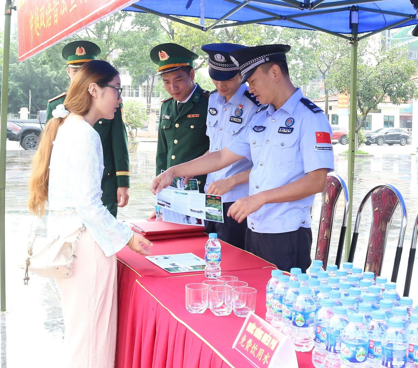 Lực lượng chức năng 2 bên phát tờ rơi tuyên truyền pháp luật cho du khách, cư dân biên giới. z6957371751410-b4a039decbab39bc15f7a87f114b7461.jpg