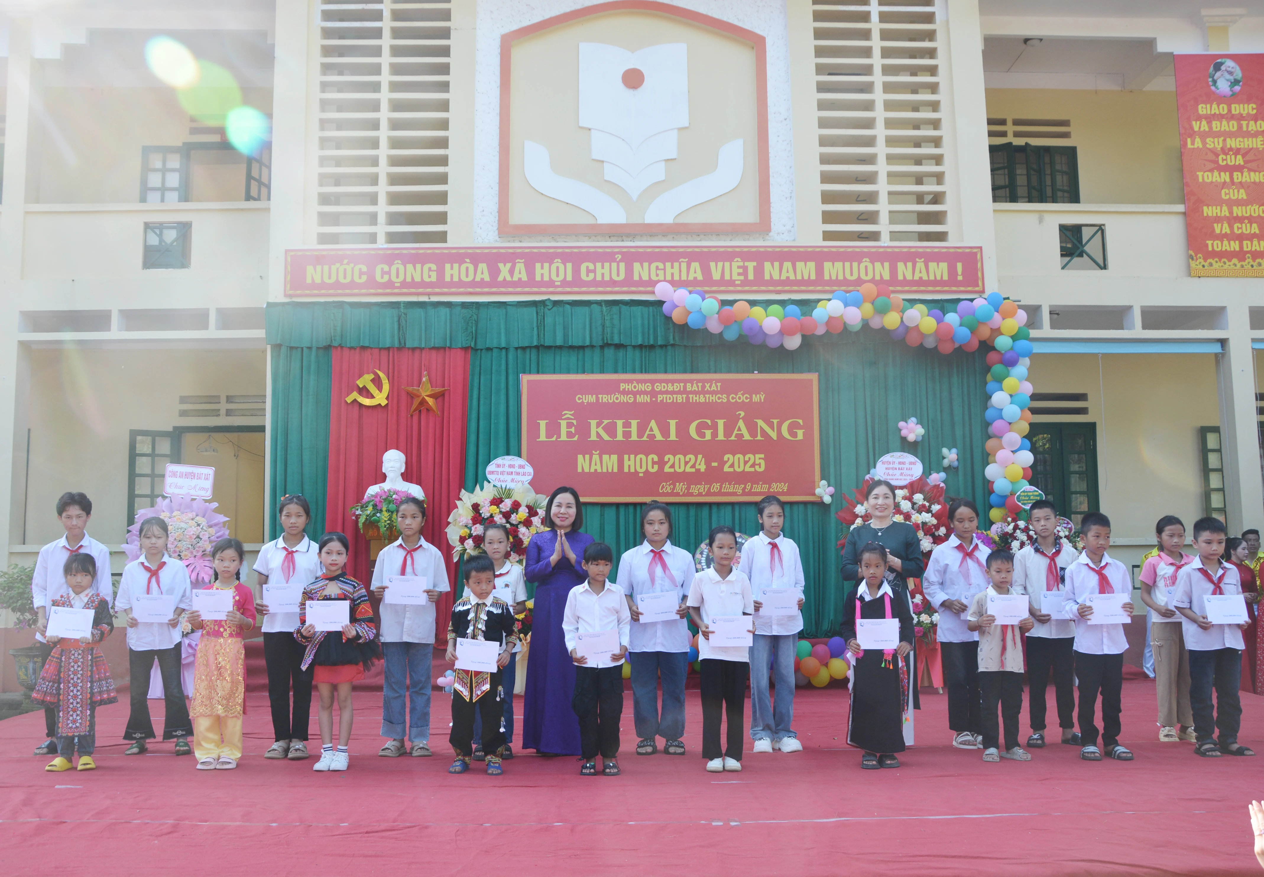 Trưởng Ban Dân vận Tỉnh ủy Lý Thị Vinh và lãnh đạo huyện Bát Xát trao học bổng cho các học sinh.