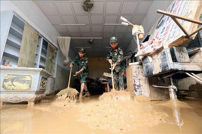 Lực lượng quân đội hỗ trợ người dân tổ 4, xã Sông Mã thu gom bùn đất, cành cây, rác bị tràn về trong đợt lũ vừa qua tại tỉnh Sơn La. lu.jpg