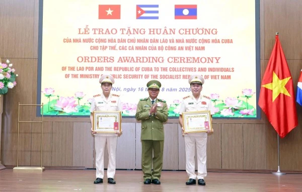 Phó Thủ tướng, Bộ trưởng Bộ Công an Lào Vilay Lakhamphong trao Huân chương Tự do hạng Nhì tặng Thứ trưởng Trần Quốc Tỏ và Thứ trưởng Lê Quốc Hùng.