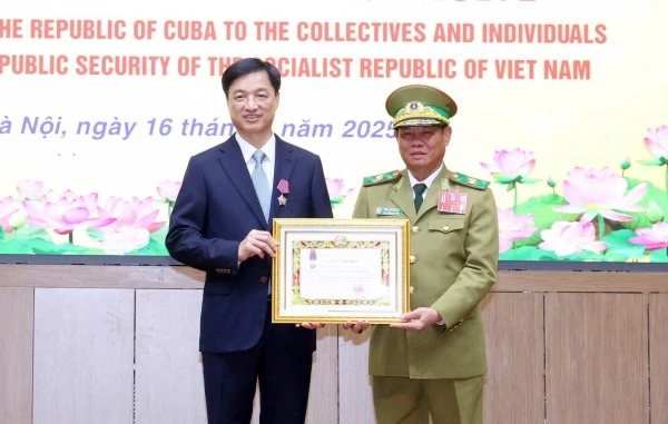 Phó Thủ tướng, Bộ trưởng Bộ Công an Lào Vilay Lakhamphong trao Huân chương Tự do hạng Nhì tặng đồng chí Nguyễn Duy Ngọc.