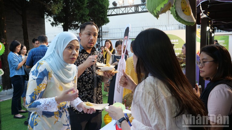 Khách mời thưởng thức sầu riêng tại gian hàng Thái Lan. Khách mời thưởng thức sầu riêng tại gian hàng Thái Lan.