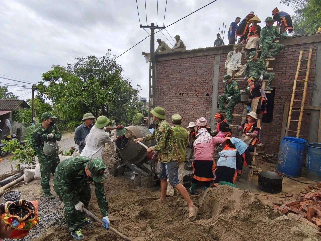 Cán bộ chiến sĩ Đồn biên phòng Cửa khẩu Ma Lù Thàng, BĐBP Lai Châu cùng chính quyền, Mặt trận và bà con đồng bào dân tộc Dao đỏ ở xã Phong Thổ xây nhà cho người nghèo.