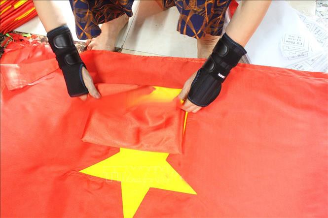 Những lá cờ được làm ra từ bàn tay tài hoa, cần mẫn của người thợ thông Giáp Long, xã Chương Dương, thành phố Hà Nội. co-5.jpg