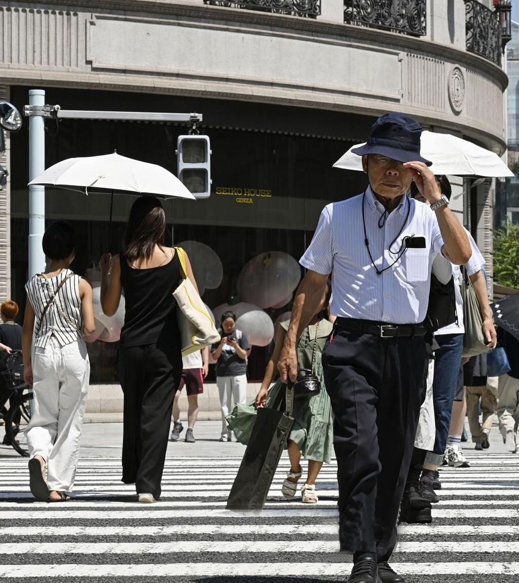 Người dân di chuyển dưới trời nắng gắt ở Tokyo, Nhật Bản, ngày 27/8/2025. nang-nb.jpg