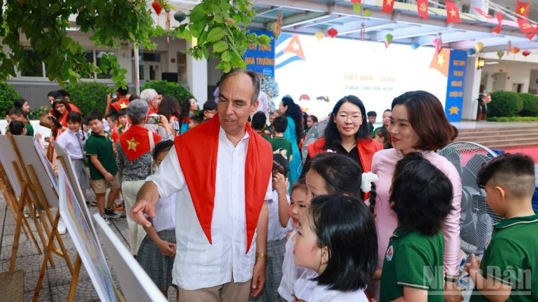 Đại sứ Cuba tại Việt Nam Rogelio Polanco Fuentes và giáo viên học sinh tiểu học Việt Nam-Cuba xem Triển lãm ảnh.