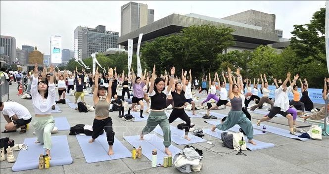 Tại Quảng trường Gwanghwamun ở trung tâm Seoul, với khẩu hiệu “Tìm kiếm hào quang của bạn”, hơn 1.000 người tham gia đã tập trung ngoài trời để thực hành Surya Namaskar - một chuỗi động tác yoga gồm 12 tư thế - cũng như Hatha và Vinyasa yoga, hai phong cách phổ biến. 18-7-tap-yoga-1-2742.jpg