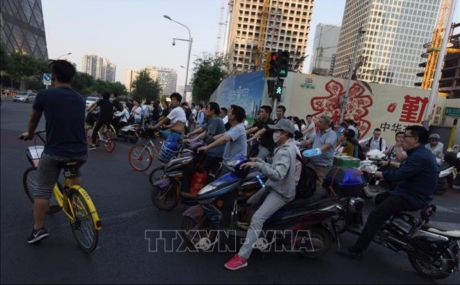 Người dân đi xe đạp điện trên một đường phố ở Bắc Kinh. xe-dap-dien-tq-1853.jpg