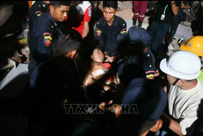 Cô Phyu Lay Khaing, 30 tuổi, được các nhân viên cứu hộ đưa ra khỏi đống đổ nát của toà chung cư Sky Villa bị sập trong trận động đất ở Mandalay, Myanmar, ngày 29/3/2025. Ảnh: The Sun/TTXVN