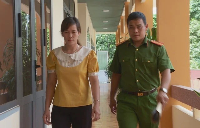 Thiếu tá Vũ Tiến Dũng dẫn giải đối tượng Hoàng Thị Lên - kẻ bán mẹ con chị N.T.S. sang Trung Quốc.