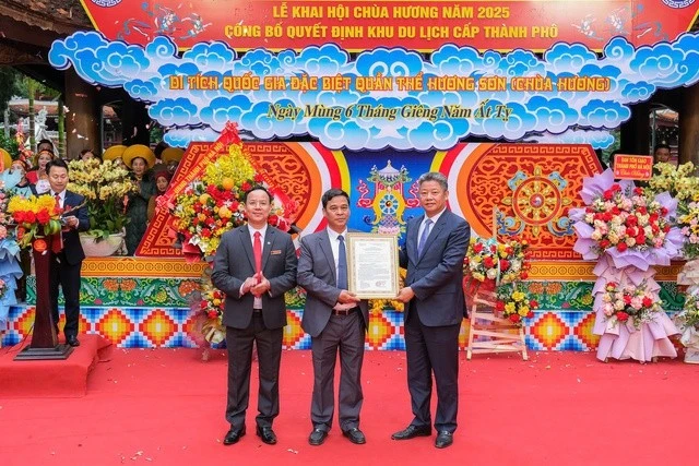 Phó Chủ tịch UBND TP Hà Nội Nguyễn Mạnh Quyền (bìa phải ngoài cùng) trao quyết định công nhận khu du lịch cấp thành phố cho Di tích quốc gia đặc biệt quần thể Hương Sơn.