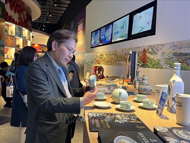 Visitantes observan productos cerámicos vietnamitas expuestos en la Casa de Vietnam durante la EXPO 2025. Foto: Nguyen Tuyen/VNA Khách tham quan sản phẩm gốm sứ của Việt Nam được trưng bày tại Nhà Việt Nam ở EXPO 2025. Ảnh: Nguyễn Tuyến/TTXVN