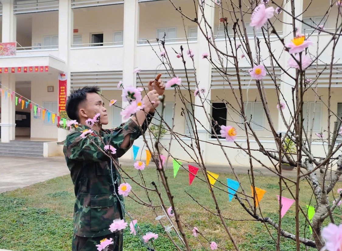 Phía ngoài tiền sảnh khu nhà chỉ huy các cơ quan, đơn vị trực thuộc Trung đoàn 254 rợp màu cờ, hoa đào khoe sắc thắm đón chào năm mới. 115.jpg