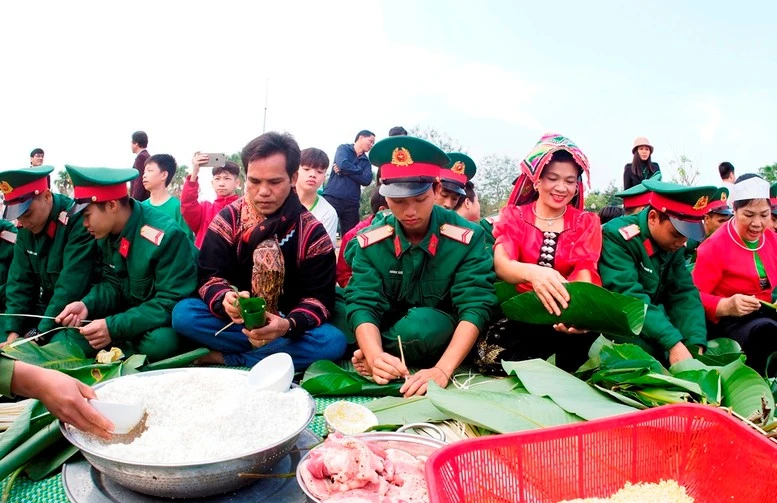 Cộng đồng các dân tộc đang hoạt động tại "Làng" cùng các chiến sĩ tham gia gói bánh chưng. Ảnh: Làng Văn hóa - Du lịch các dân tộc Việt Nam