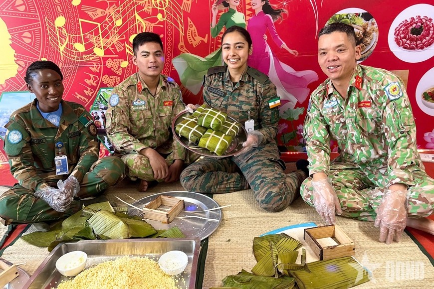 Bạn bè quốc tế thích thú gói bánh chưng Việt Nam. Ảnh: HẢI YẾN