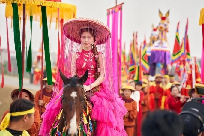 Hòa Minzy tái hiện cảnh rước kiệu trên đê Lạc Xá trong MV Bắc Bling. Ảnh: NVCC