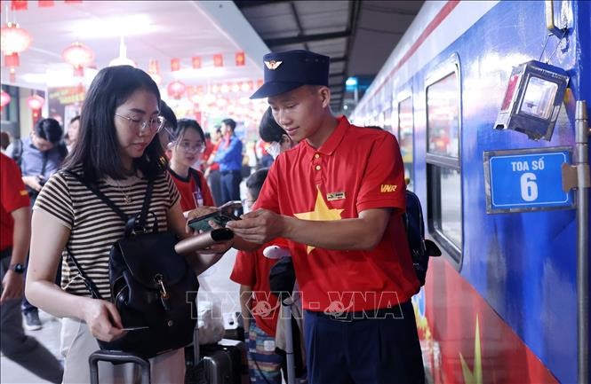 បុគ្គលិករថភ្លើង SE1 ណែនាំមនុស្សឱ្យឡើងរថភ្លើង។ Nhân viên tàu SE1 hướng dẫn người dân lên tàu.