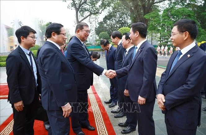 Thủ tướng Phạm Minh Chính giới thiệu với Thủ tướng Nhật Bản Ishiba Shigeru thành viên đoàn Việt Nam tham dự lễ đón. Ảnh: Dương Giang-TTXVN