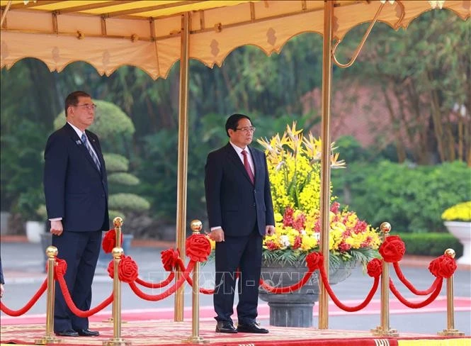 Thủ tướng Phạm Minh Chính và Thủ tướng Nhật Bản Ishiba Shigeru trên bục danh dự, nghe quân nhạc cử Quốc thiều hai nước. Ảnh: Dương Giang/TTXVN