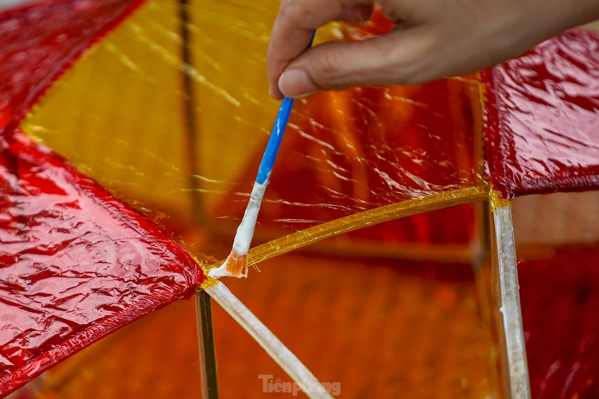 "Công đoạn nào khó thì người lớn sẽ làm phụ các con. Mấy bé thích cầm cọ quét keo và dán giấy kính. Hoạt động này cũng một phần giáo dục các bé về nét văn hóa mà ngày nay ít thấy nữa khi lồng đèn gắn pin, phát nhạc bán đại trà. Chiếc đèn ông sao truyền thống có hình sao vàng năm cánh. Đây cũng là hình ảnh quen thuộc chúng ta vẫn thường thấy trên lá quốc kỳ", chị Hồng Nhung (áo trắng) chia sẻ.