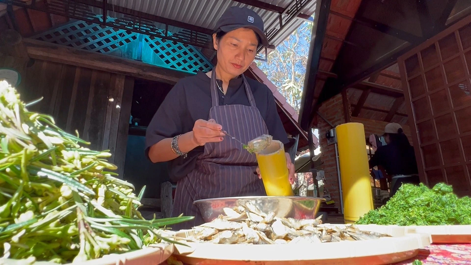 Chị H'Minh tỉ mỉ chuẩn bị món ăn cho khách.